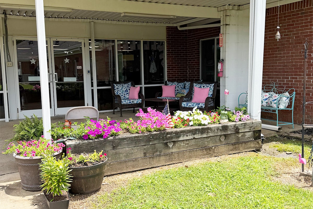 Back porch with flowerbeds at Cherrywood Post Acute